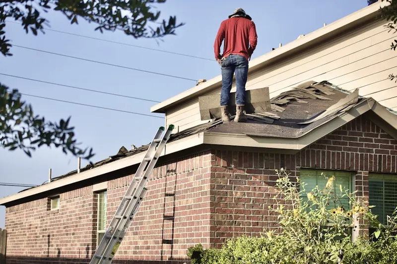 Professional roofer working on a residential roof in Bantam